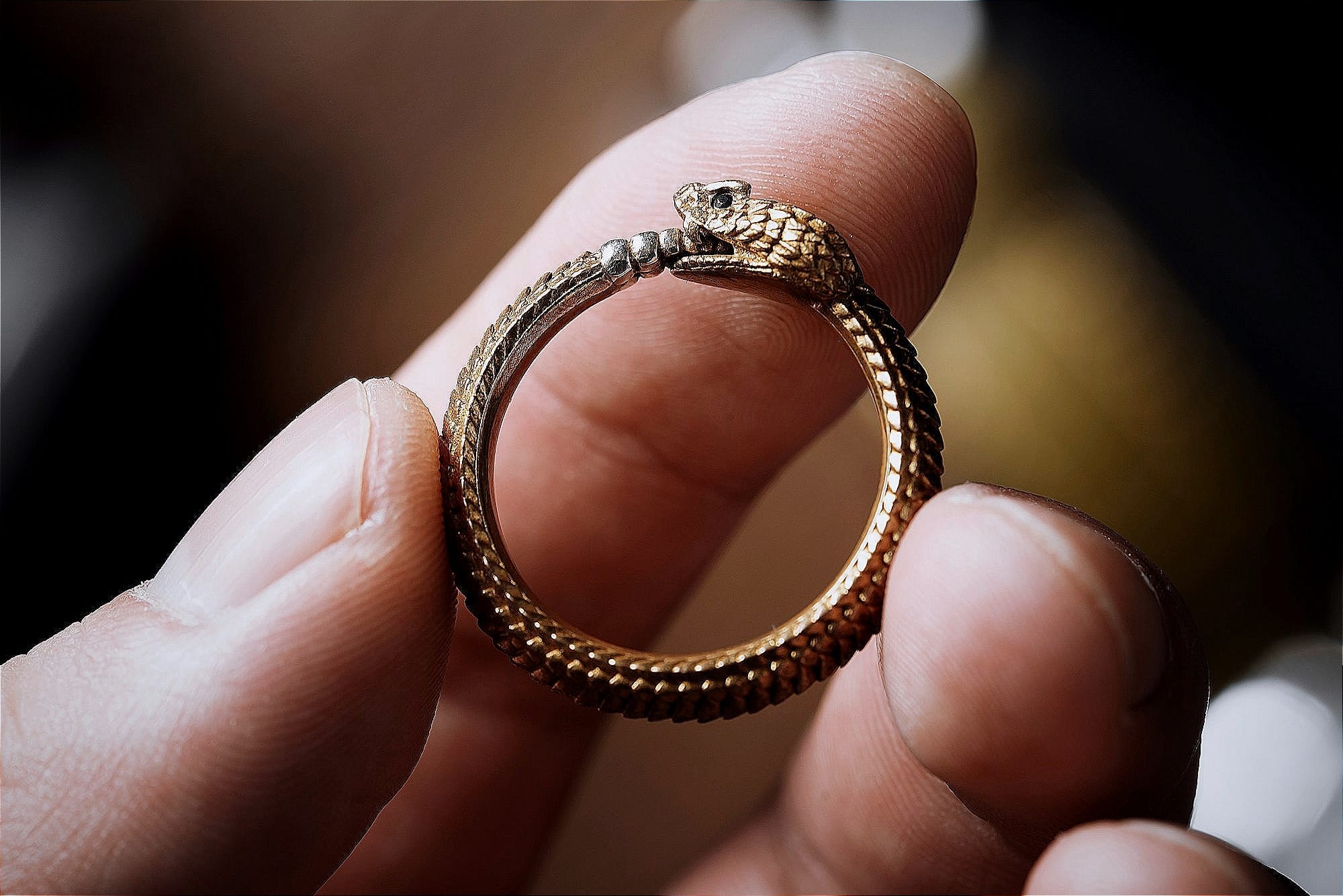 a person holding a gold ring in their hand