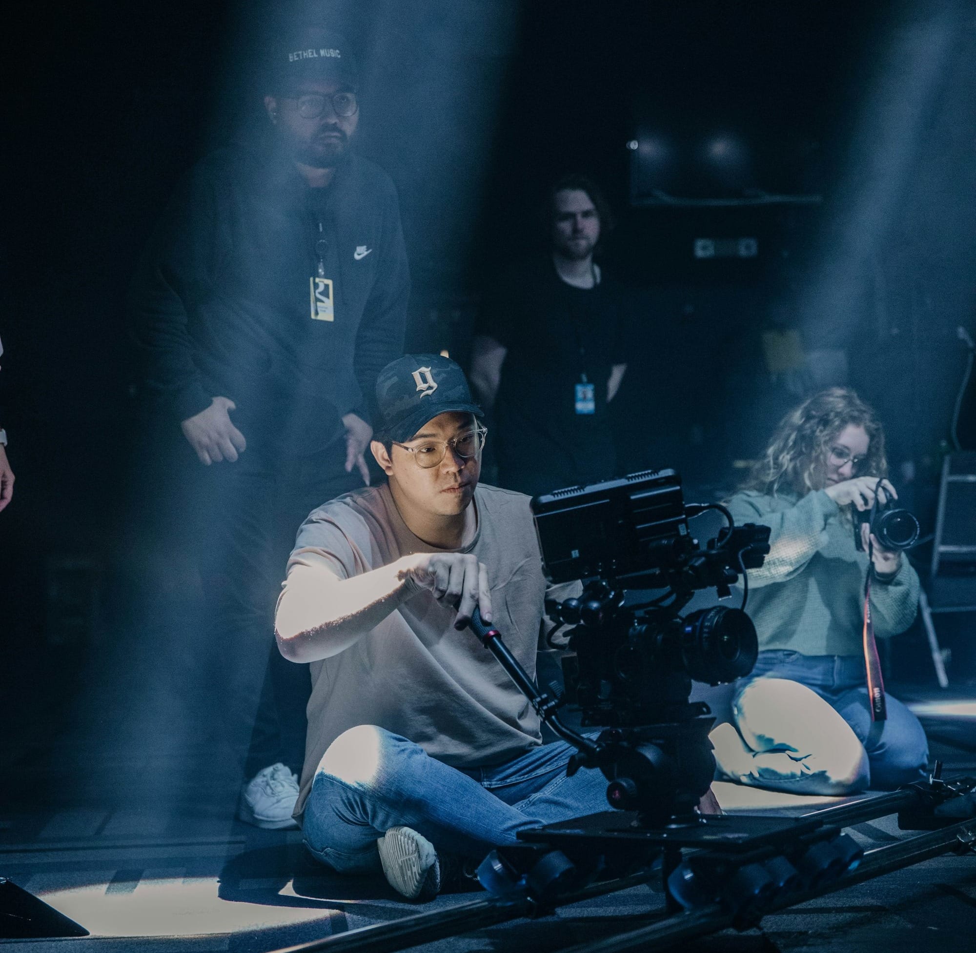 a man sitting on the ground in front of a camera