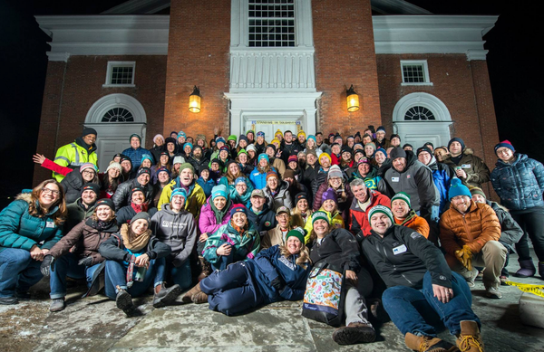 A group of people outdoors at night smiling at the camera before an all-night fundraising event.