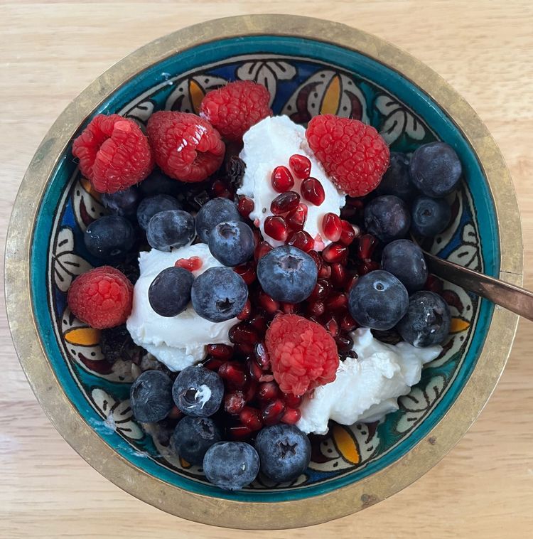 A pretty morrocan bowl full of porridge, flaxseed, sunflower and poppy seeds, blueberries, raspberries, pomegranate seeds and greek youghurt