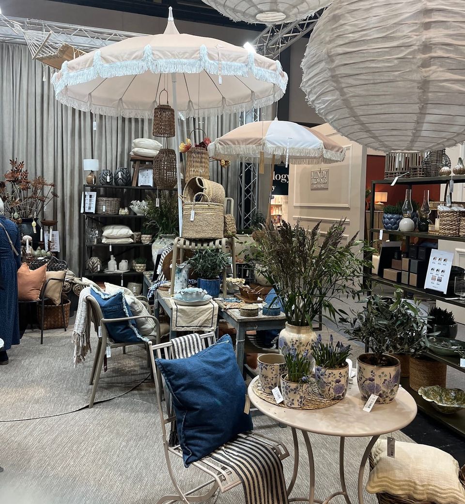 An area with lots of garden furniture, umbrellas and other household items on show, mainly in creams, whites and navy blue accents with the odd pop of pale terracotta.