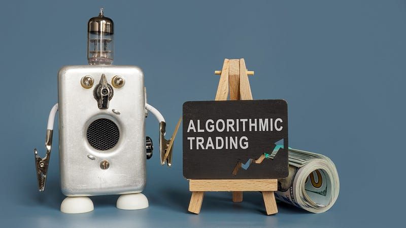 Fun little robot shaped like a radio, pointing to a chalk-board with the words “Algorithmic Trading”.