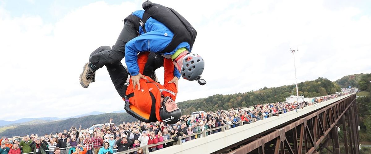 two people BASE jumping off of a bridge