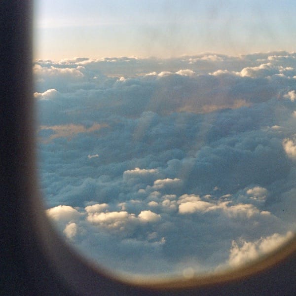 Fluffy clouds viewed through an airplane window.