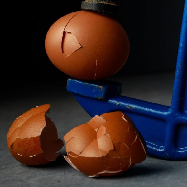a broken egg sitting on top of a blue object