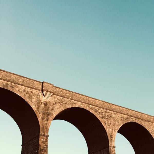 brown concrete bridge under blue sky during daytime