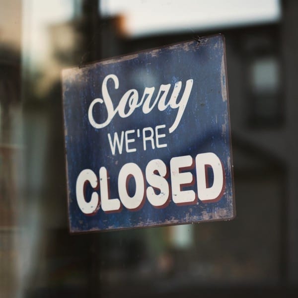 Sorry we're closed signage hanged on glass door