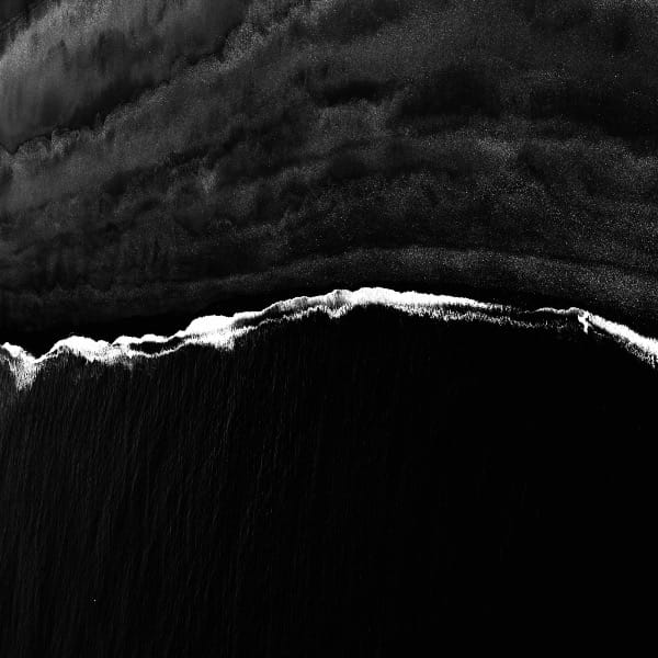 aerial black sand beach with wave