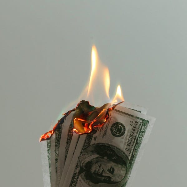 time lapse photography of several burning US dollar banknotes