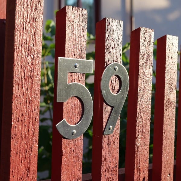 a red fence with a metal number on it