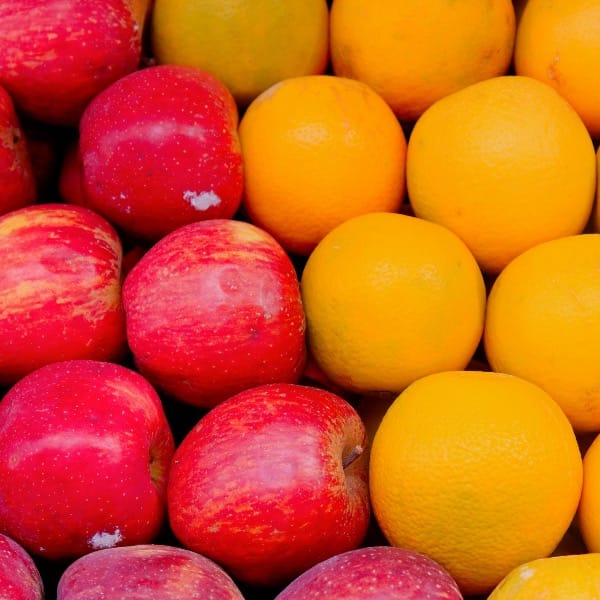 a pile of oranges and apples sitting next to each other