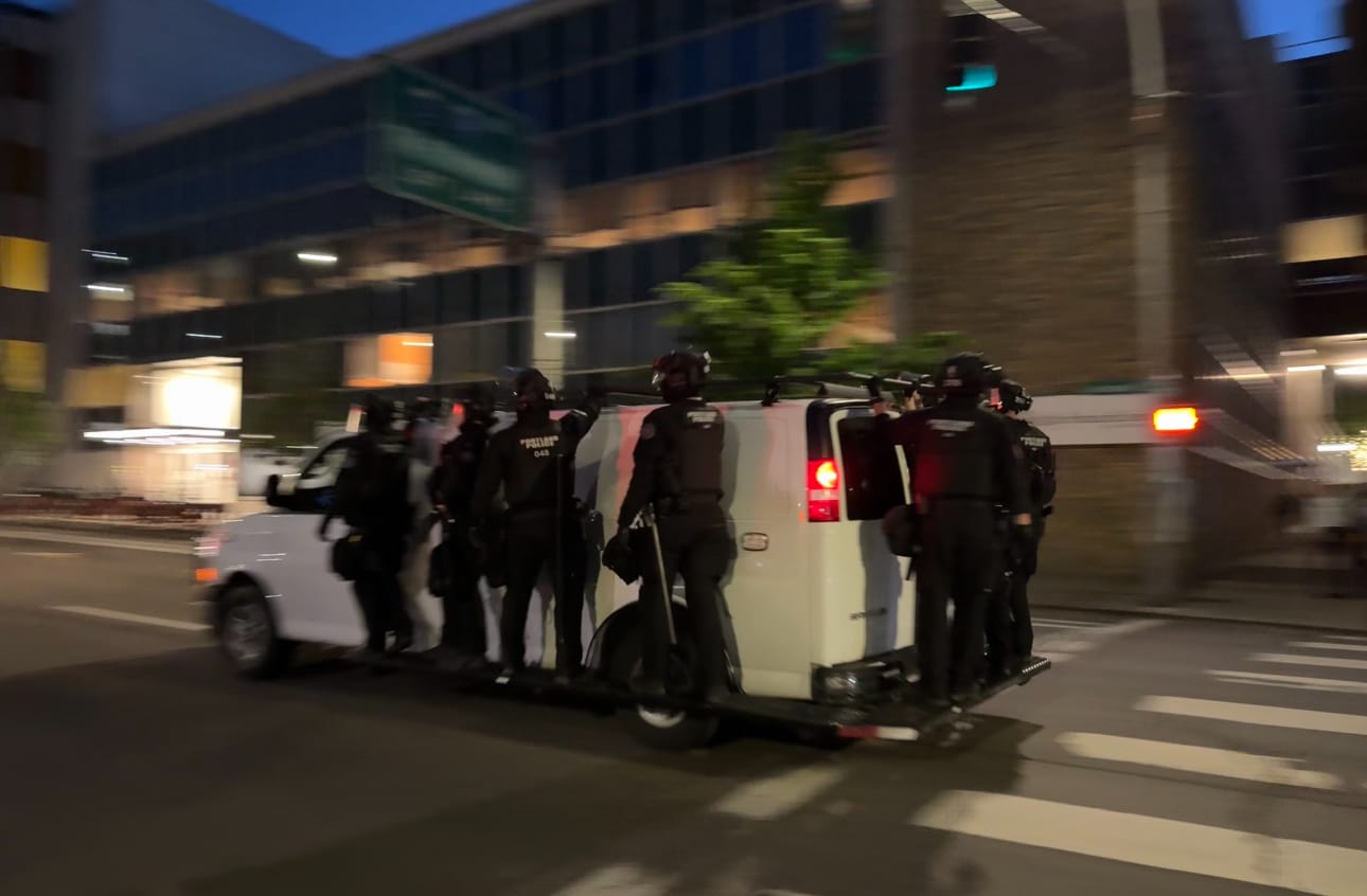 PPB riot police hanging on the van