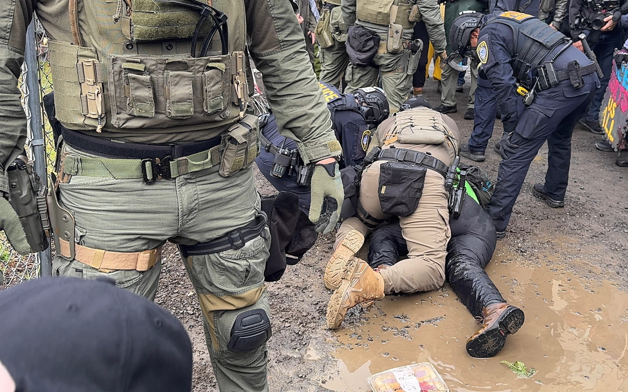 Protester face down on the ground with multiple federal agents on them after being tackled