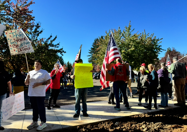 A group of far right protesters standing outside of David Douglas High School holding signs and American flags