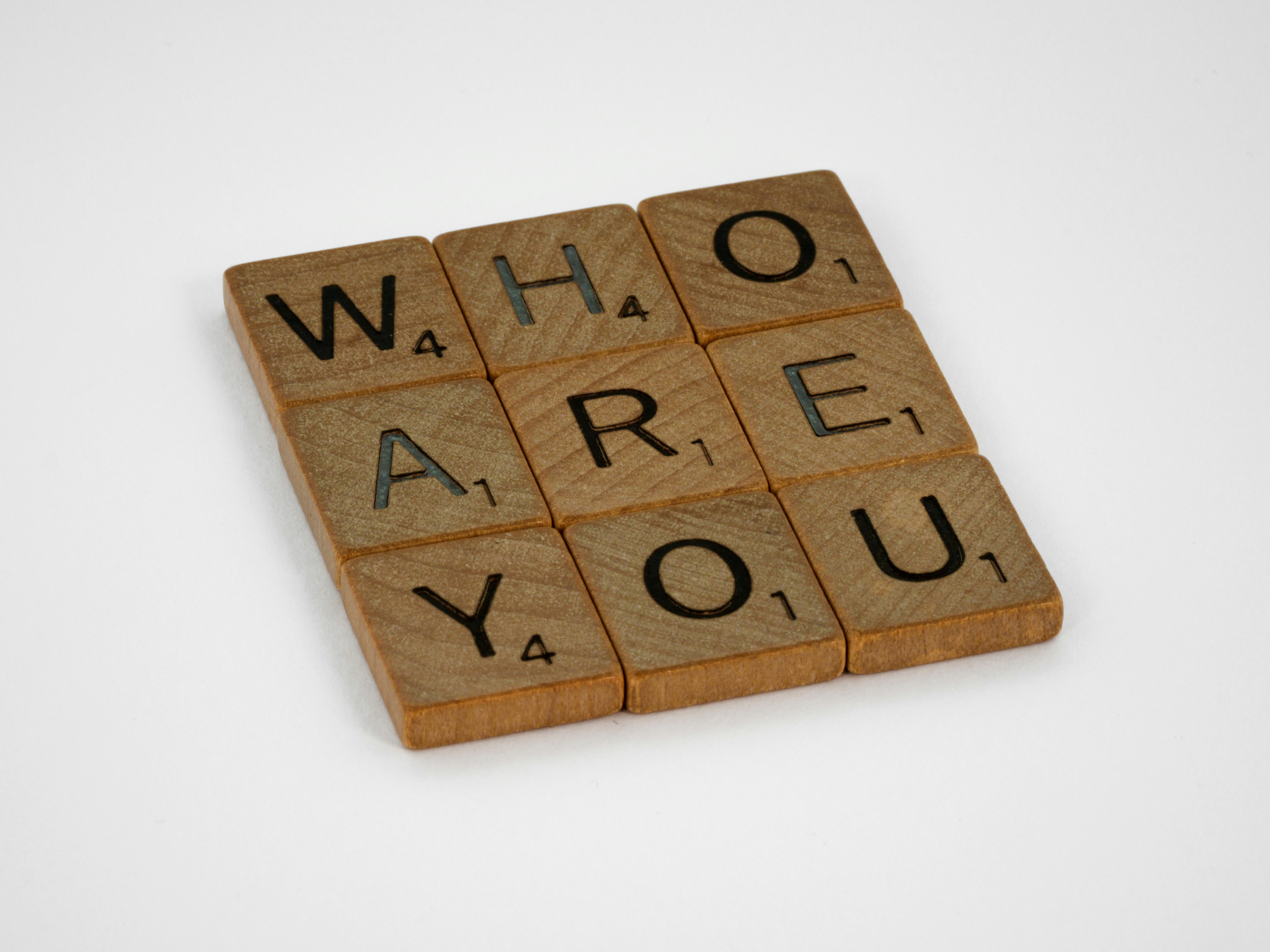Scrabble tiles spelling out "WHO ARE YOU".