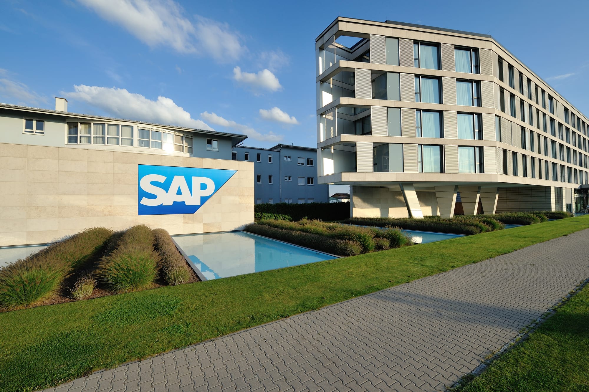 SAP logo on concreate wall next to modern glass and concrete low-rise building.
