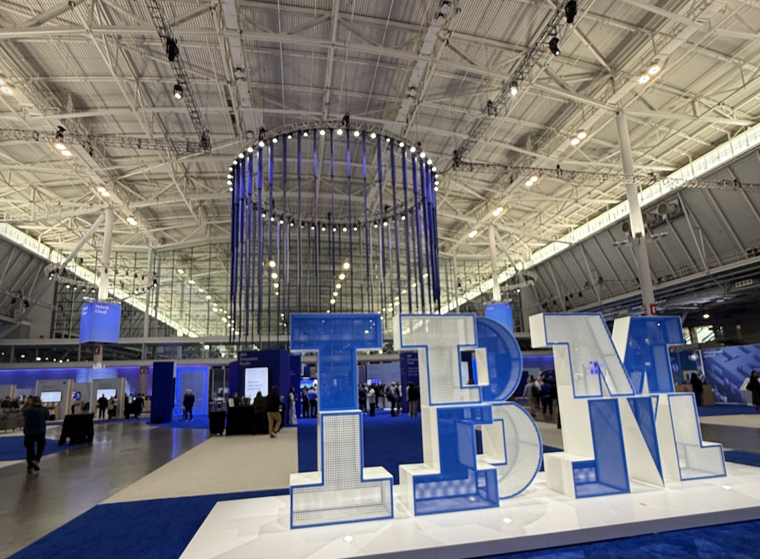 Large IBM conference display inside an exhibition hall with oversized blue IBM letters.