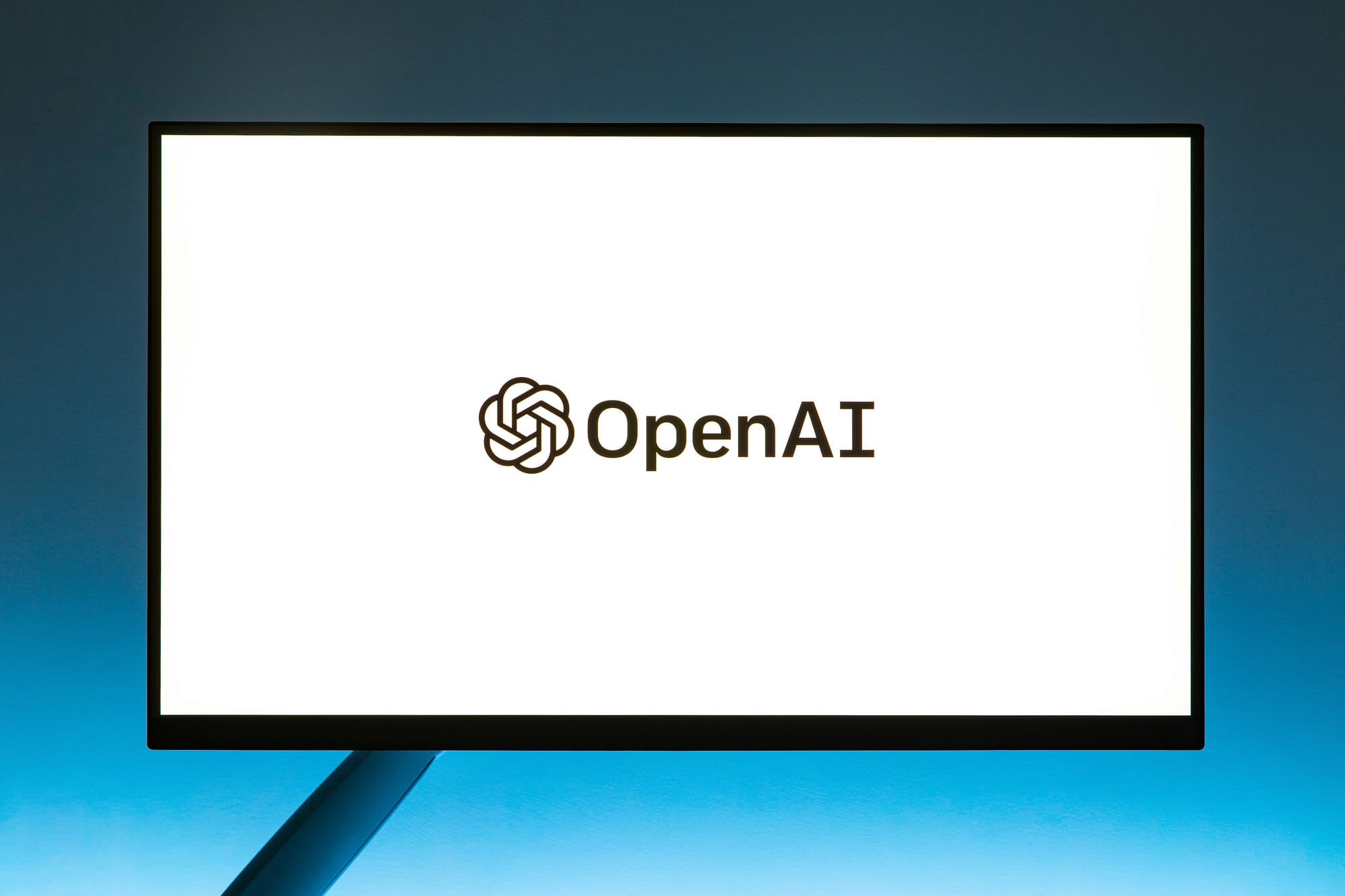 OpenAI logo and name on a screen with a blue background.