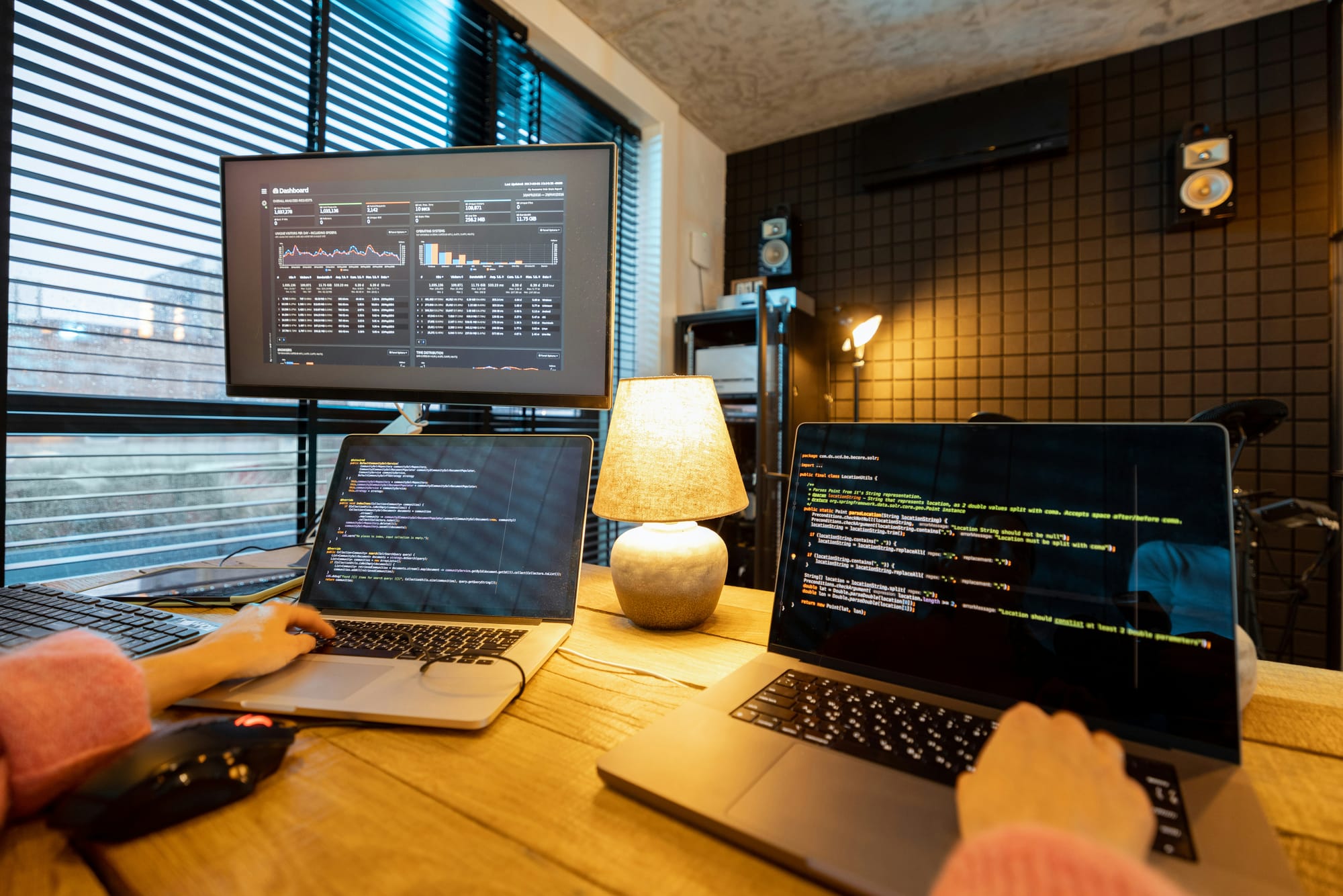 Woman programming on multiple laptops.