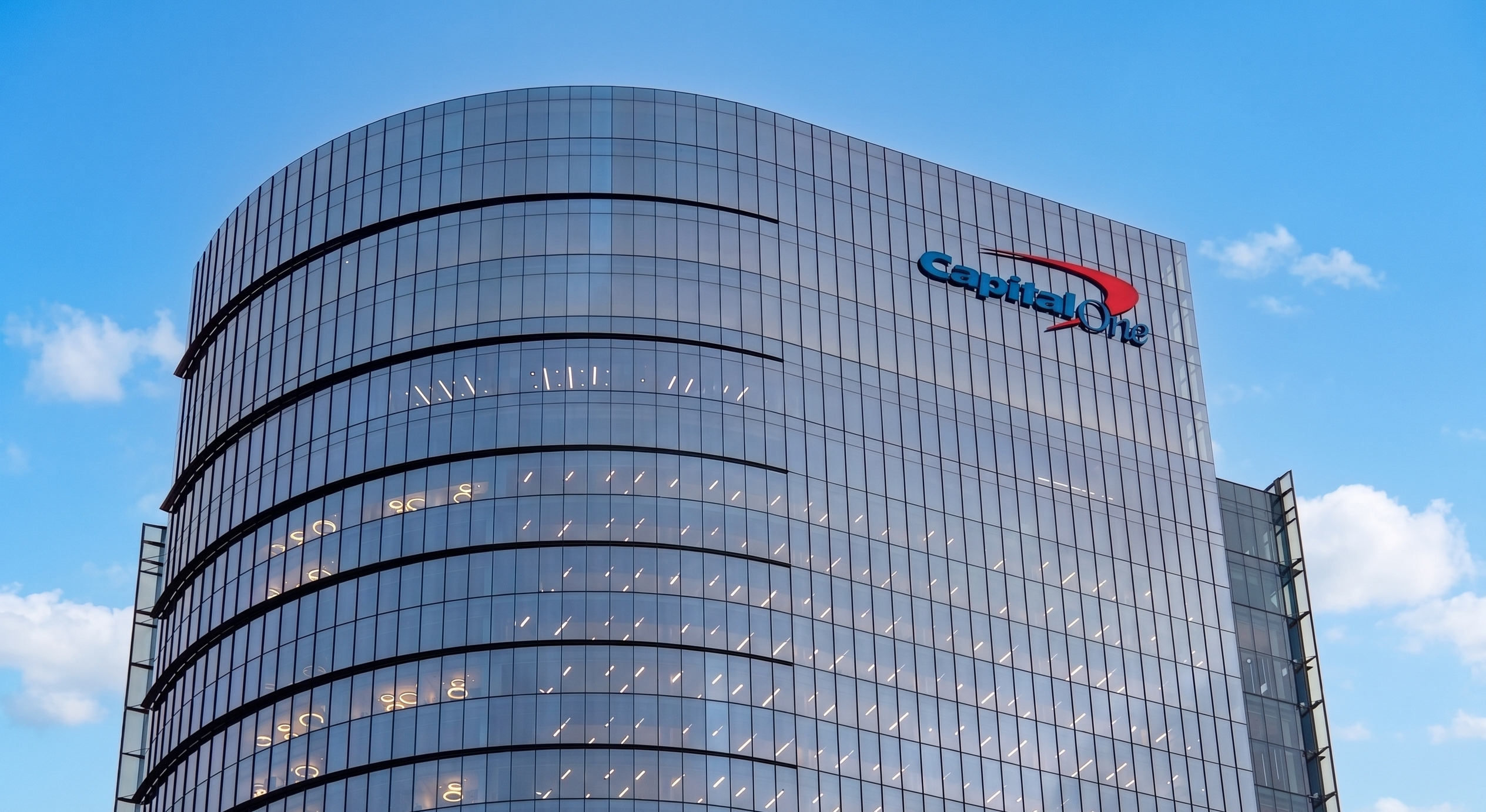 Shot of rounded glass building with Capital One logo in upper right.