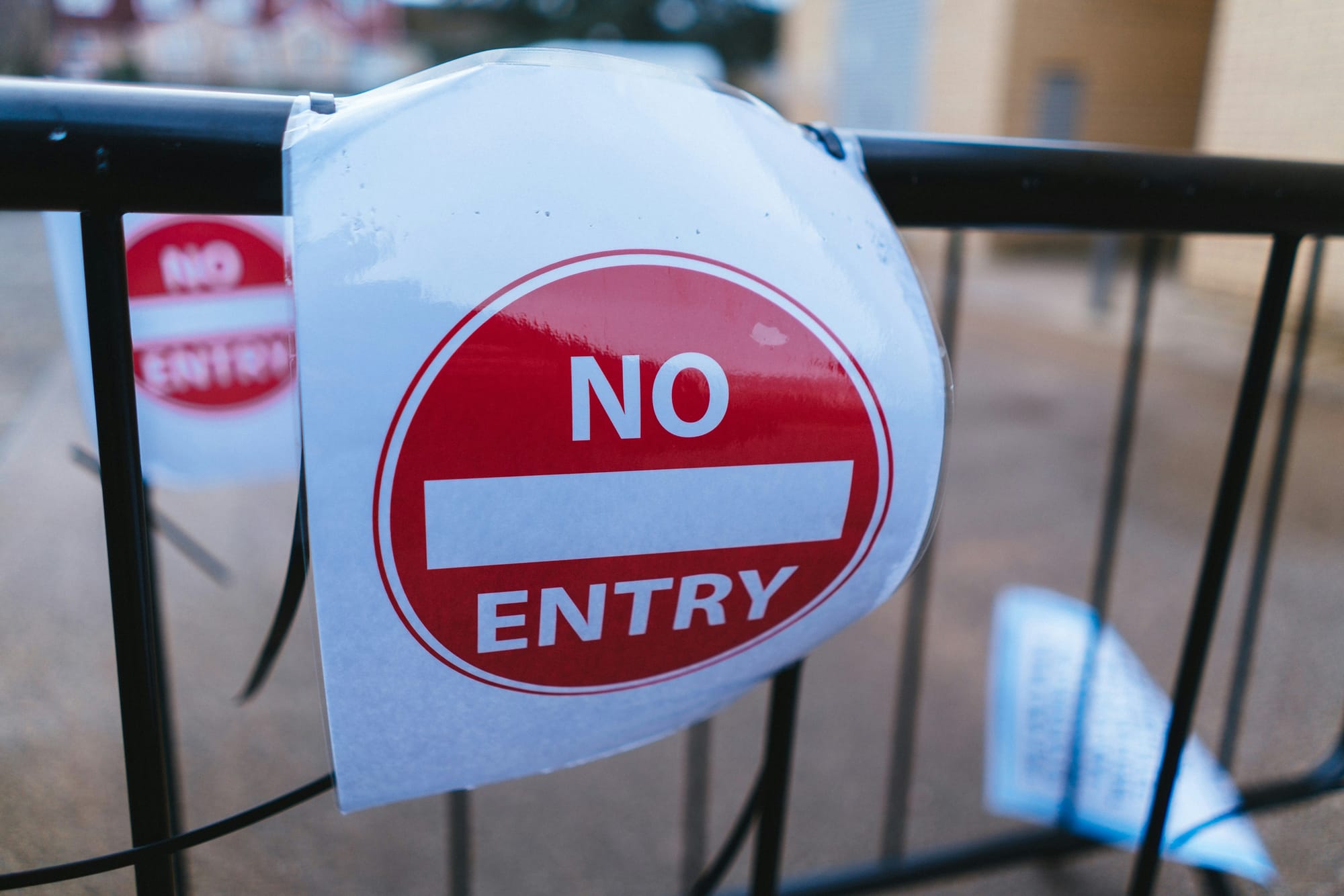 No Entry sign on a black barrier fence.