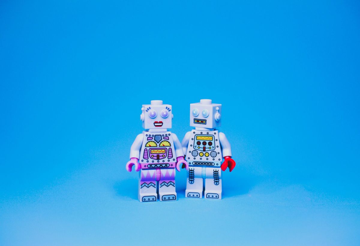 Two toy robots holding hands.