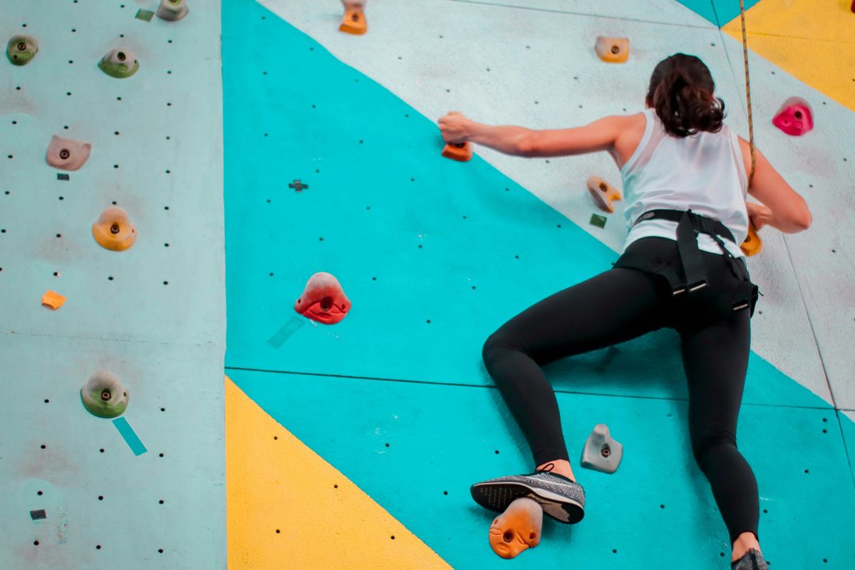 Person struggling on climbing wall.