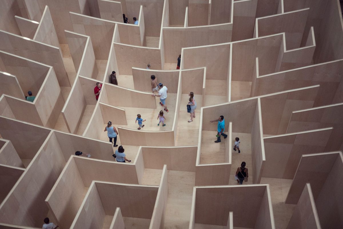 Aerial view of people navigating a large wooden maze.