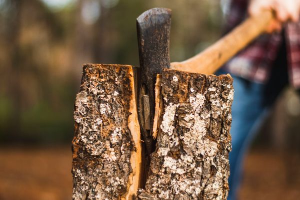 Person splitting a log with an axe.