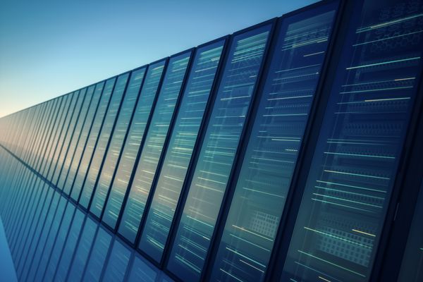 A long row of modern data center server racks with glass fronts, glowing with horizontal lines of light that suggest data act