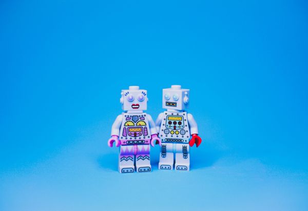 Two toy robots holding hands.