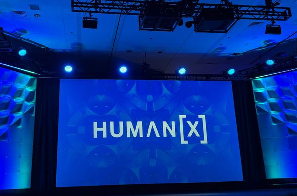 Human[X] logo on blue background on main stage at HumanX conference.