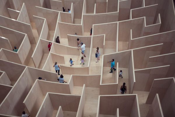 Aerial view of people navigating a large wooden maze.