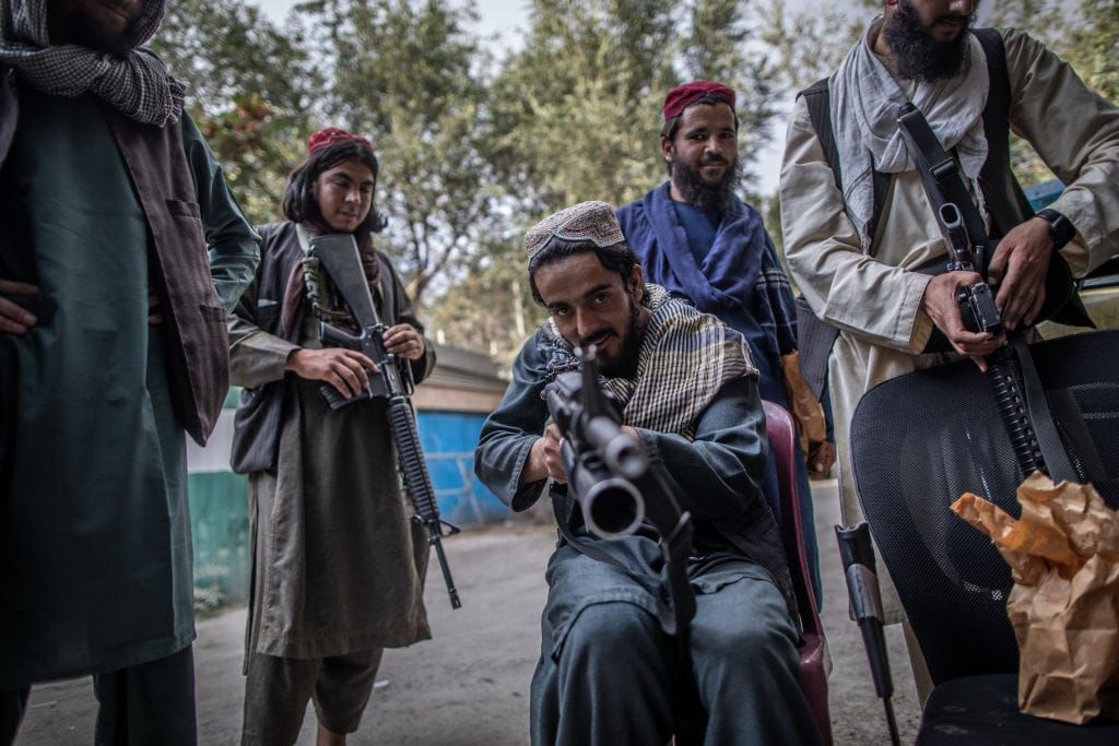 A photo of a Taliban fighter aiming his gun at the photographer