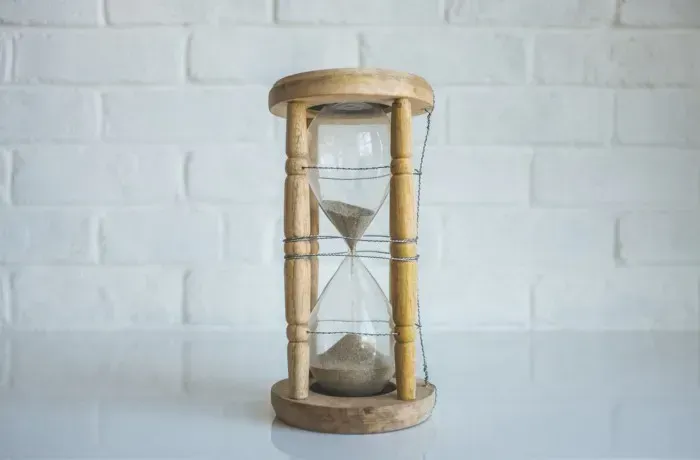 An hourglass wrapped in wire, evoking dates, time validation and the fading Moment.js library.
