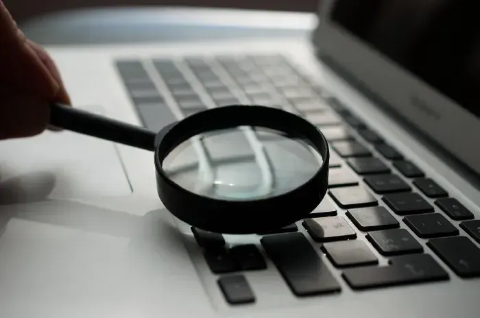 Magnifying glass on a keyboard: strict template type checking inspects Angular code for bugs