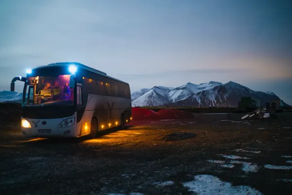 Lone bus against mountains at dusk: if it crashes, how much knowledge goes with it