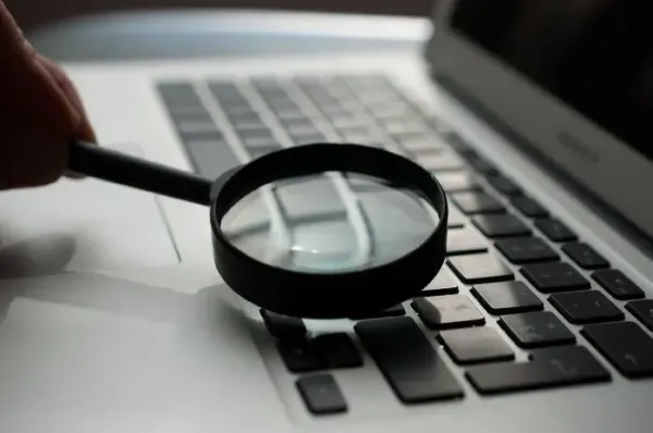 Magnifying glass on a keyboard: strict template type checking inspects Angular code for bugs