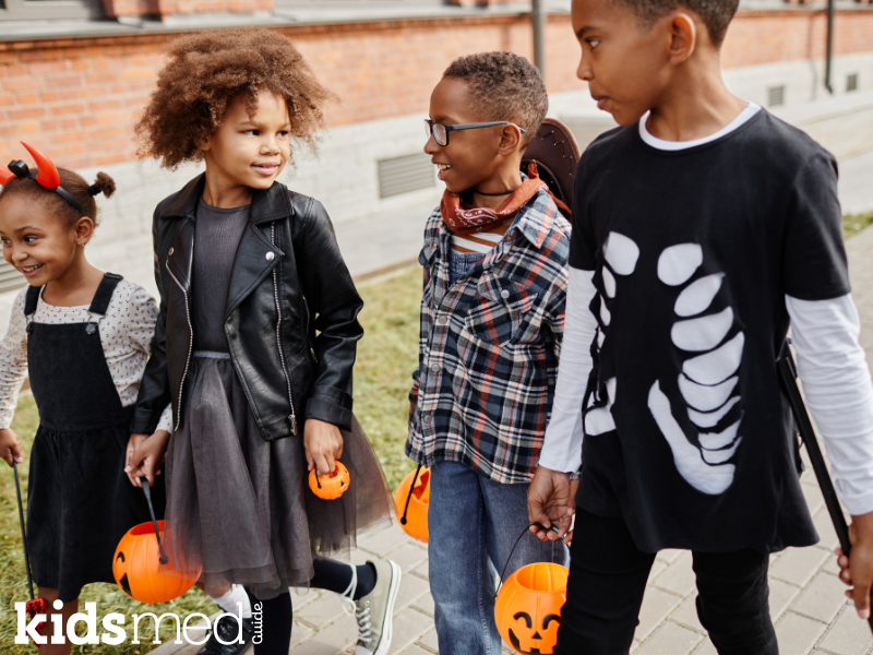Children in Halloween costumes with pumpkins.