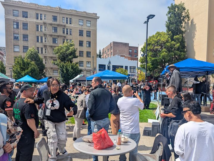 A crowd at Boedekker Park listens as Richard Beal speaks into a mic from the event stage.