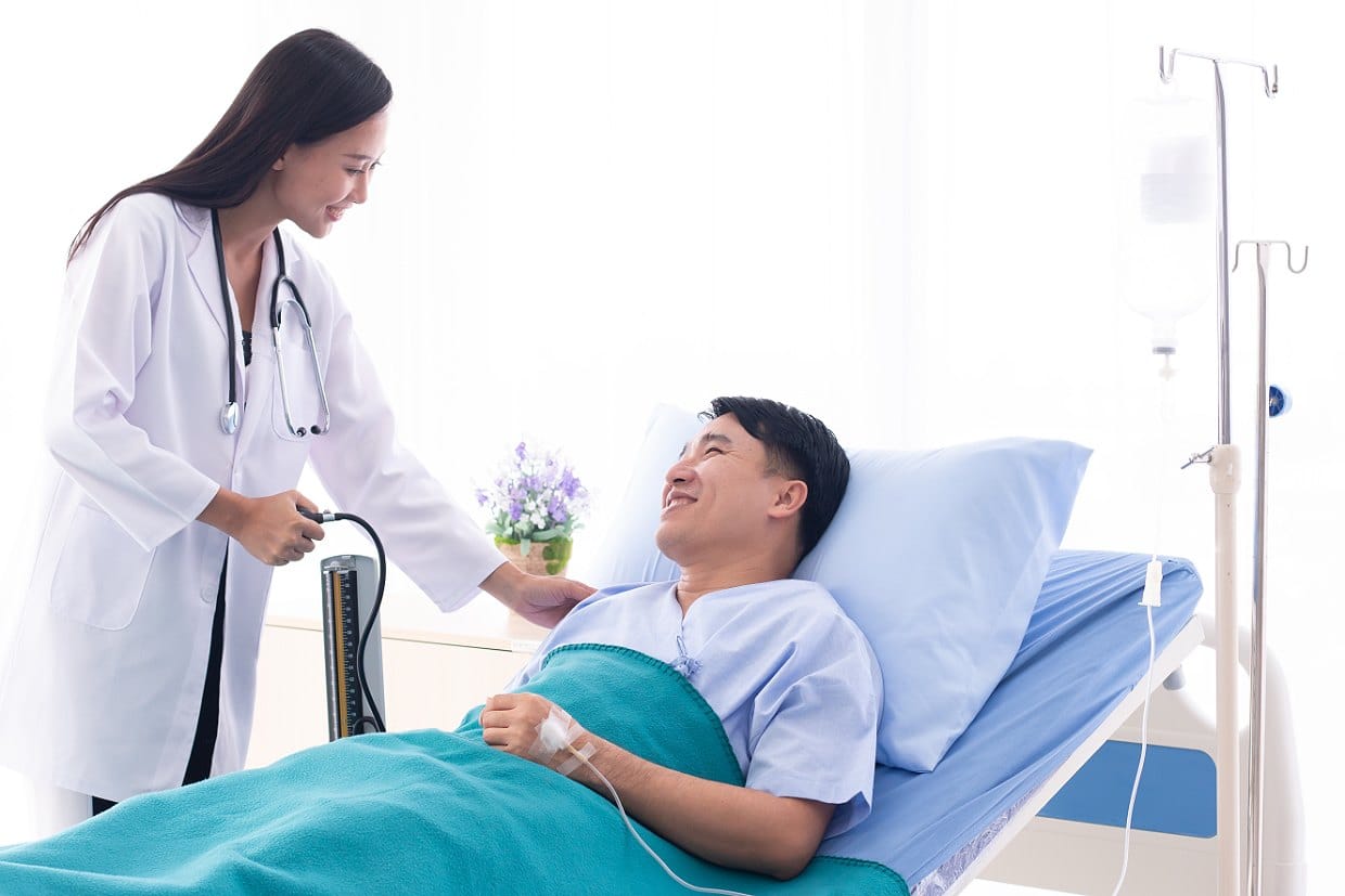 醫護人員於病房內為臥床病人量測血壓
