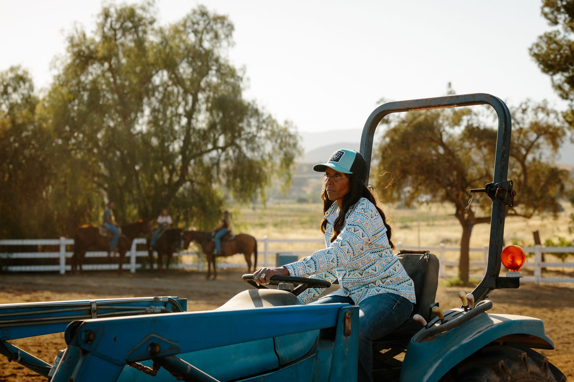 DeBoraha Townson driving a tractor on her ranch, with three of her students in the background, on June 9, 2026.