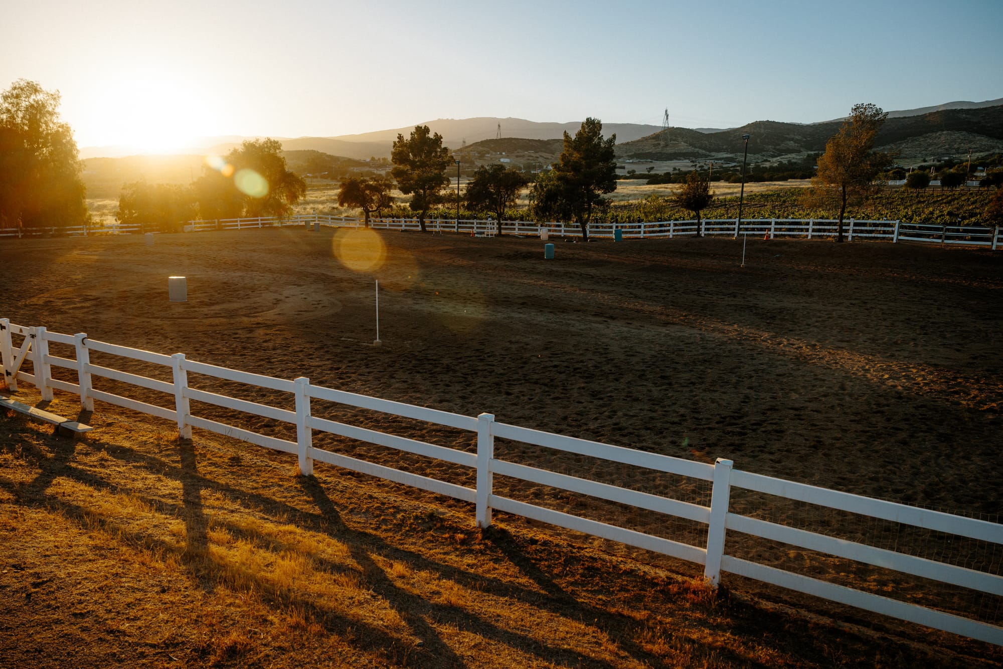 White fencing encloses the grassy area where DeBoraha Townson gives barrel racing lessons on her ranch in Agua Dulce, California.