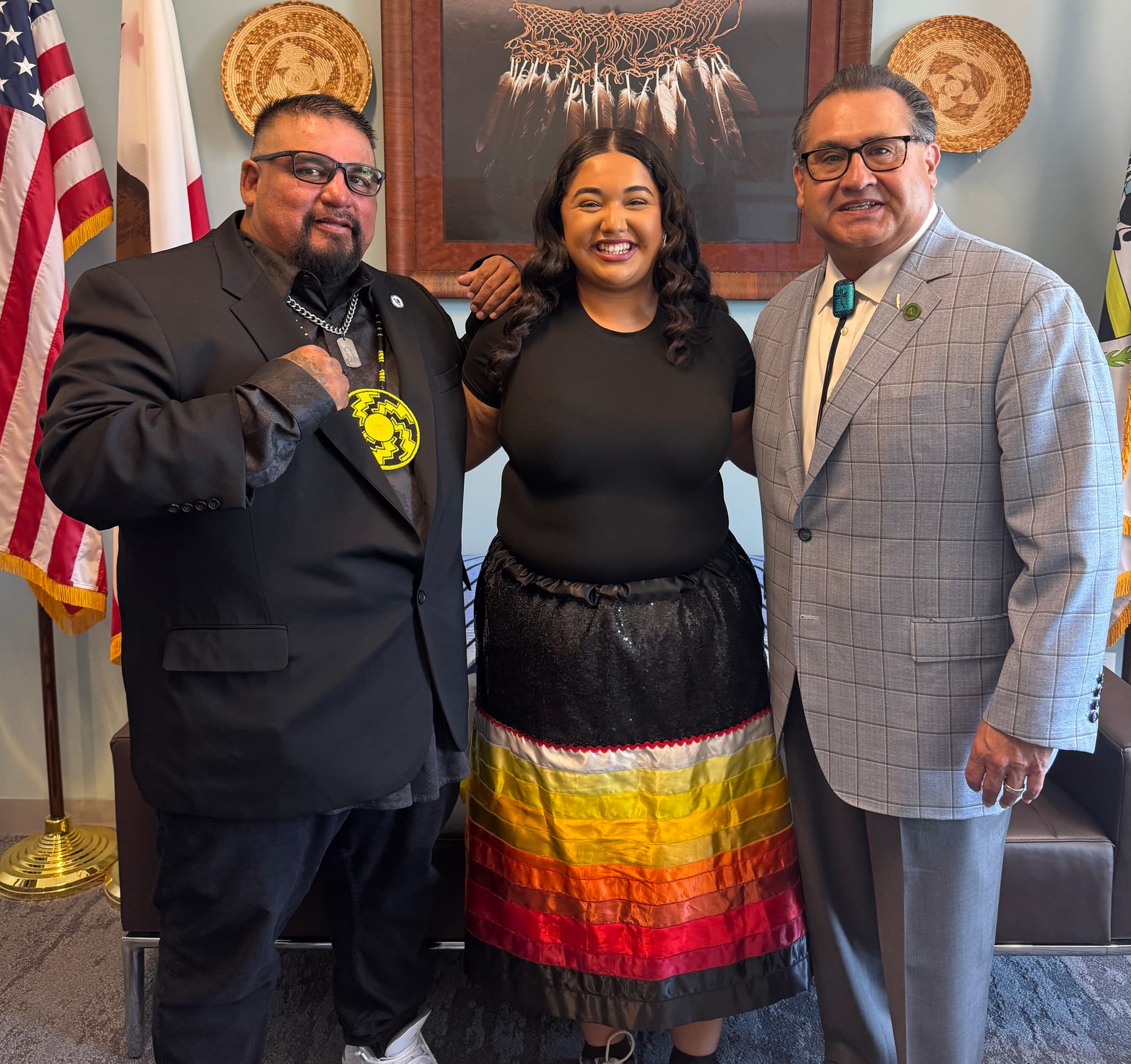 Bella Garcia (center), wearing a ribbon skirt, with Tule River Tribal Chairman Shine Nieto (left) and California Assemblyman James Ramos. Photo courtesy of Bella Garcia.