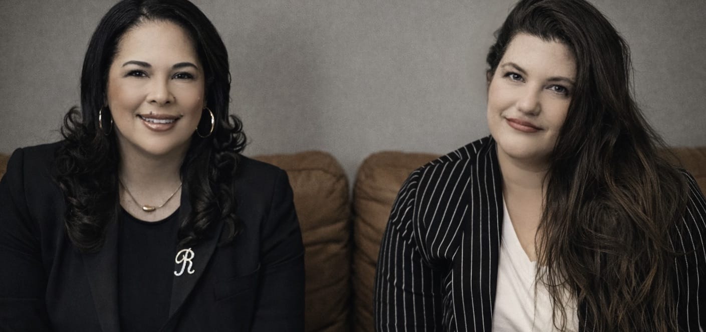 Rose Garcia and Bella Barkow, the new owners of The Dinah, a queer women's festival, sit on a brown couch. Photo courtesy of Garcia and Barkow.