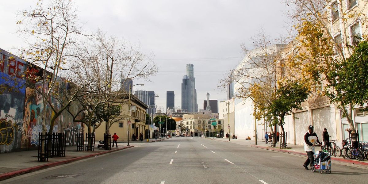 A street in the Skid Row neighborhood of Los Angeles with high-rise buildings in the background.