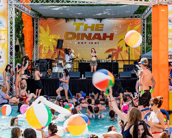 Women in bikinis play with beach balls at a pool party during The Dinah, the world's largest festival for queer women. Photo courtesy of The Dinah / RADskillZ Photography.