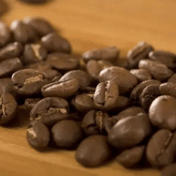 Dark roast coffee beans spread on a table