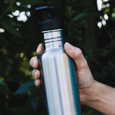 Person holding a stainless steel water bottle