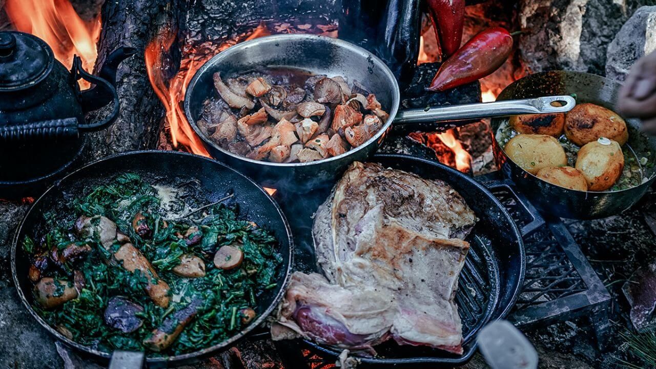 Various campfire cookware items in use while camping